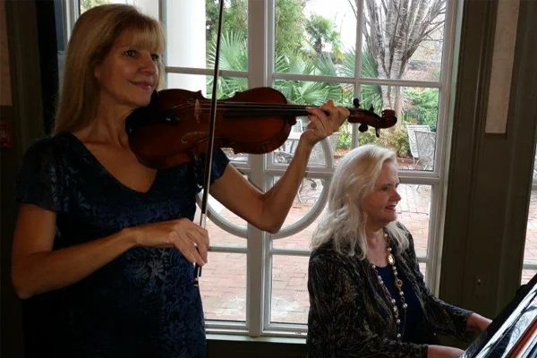 Christine playing violin with piano